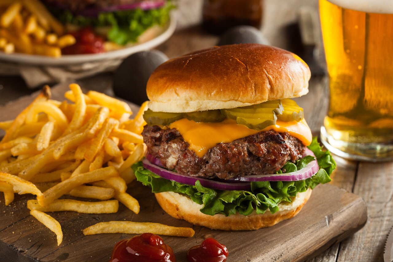Burger on cutting board with fries 
